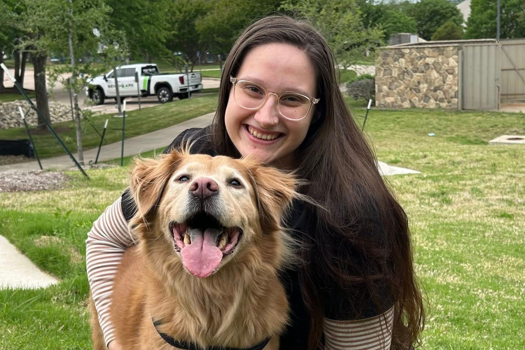 A woman gently holds a dog in her arms